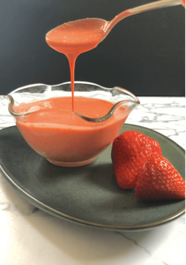 spoon pouring strawberry salad dressing