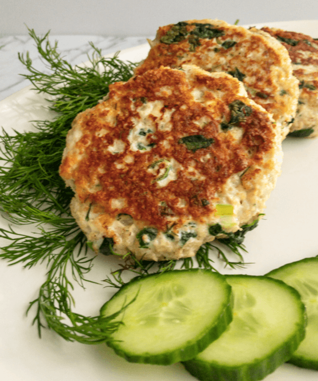 plated cooked chicken burgers with cucumber and dill