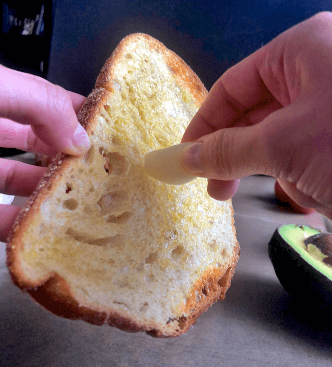 rubbing garlic clove on toast