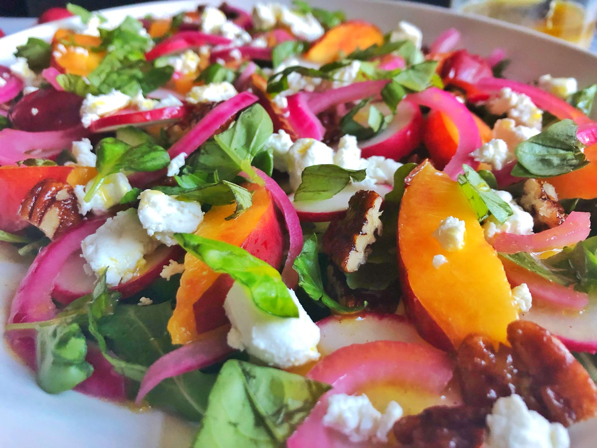 close up nectarine, arugula, radish, goat cheese salad