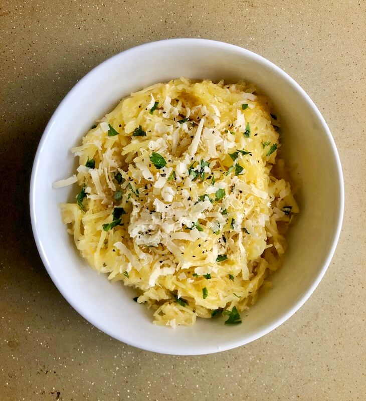 spaghetti squash in bowl sprinkled with parmesan cheese