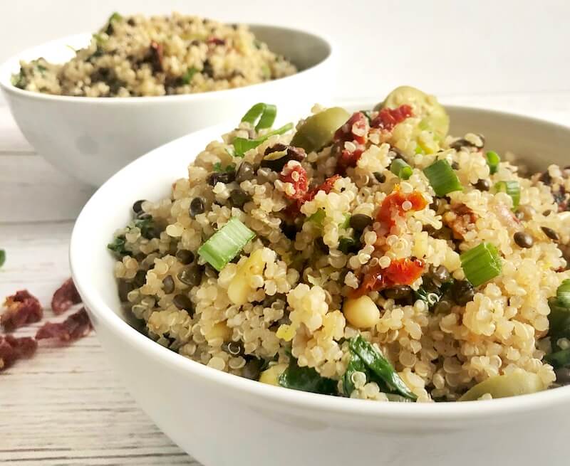 bowl of quinoa with olives, sun-dried tomatoes, lentils and spinach