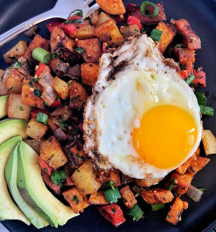 breakfast potatoes up close served with an egg and avocado