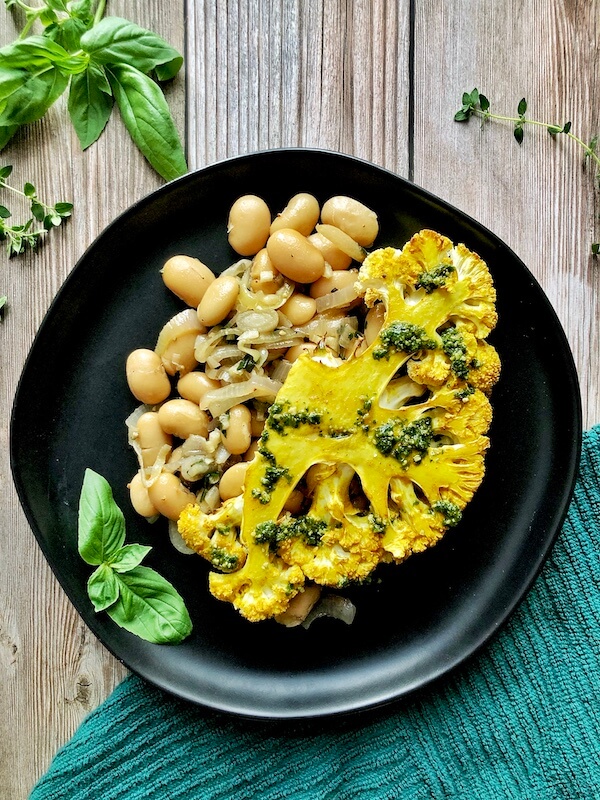 plated cauliflower over beans with pesto