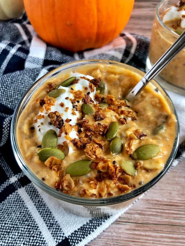 overnight oats topped with yogurt, granola, and pumpkin seeds