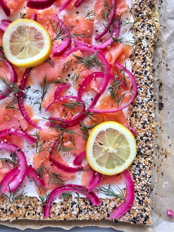 close up everything bagel with cream cheese, lox , and red onions