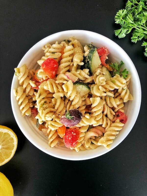 bowl of pasta salad with tomatoes, cucumber, olives and feta